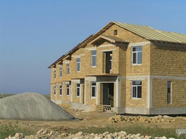 Fotografia - o casa cu un cadru din beton și pereți și frontoane de calcar.
